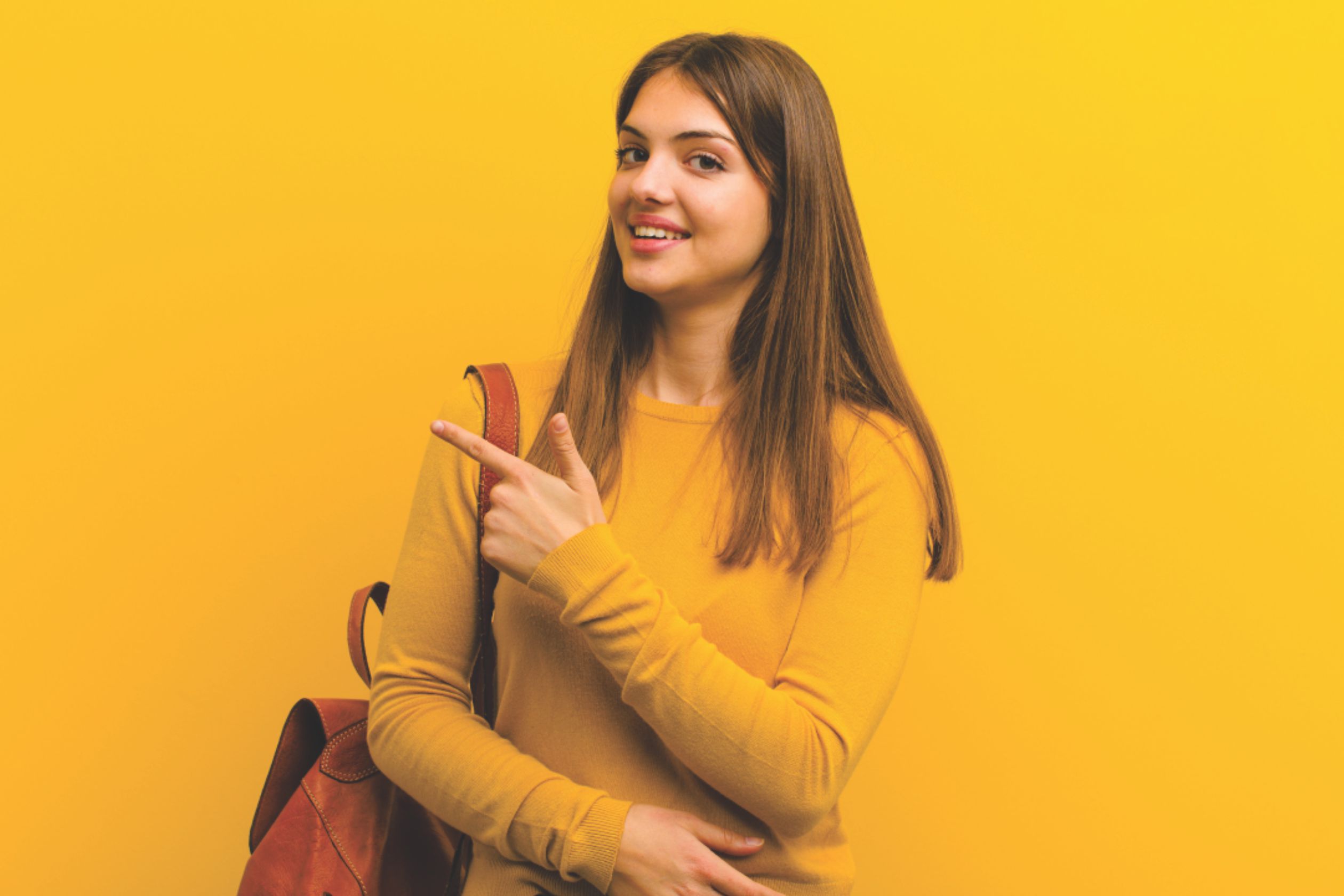 A girl student wear bag, with yellow clothes and giving simle